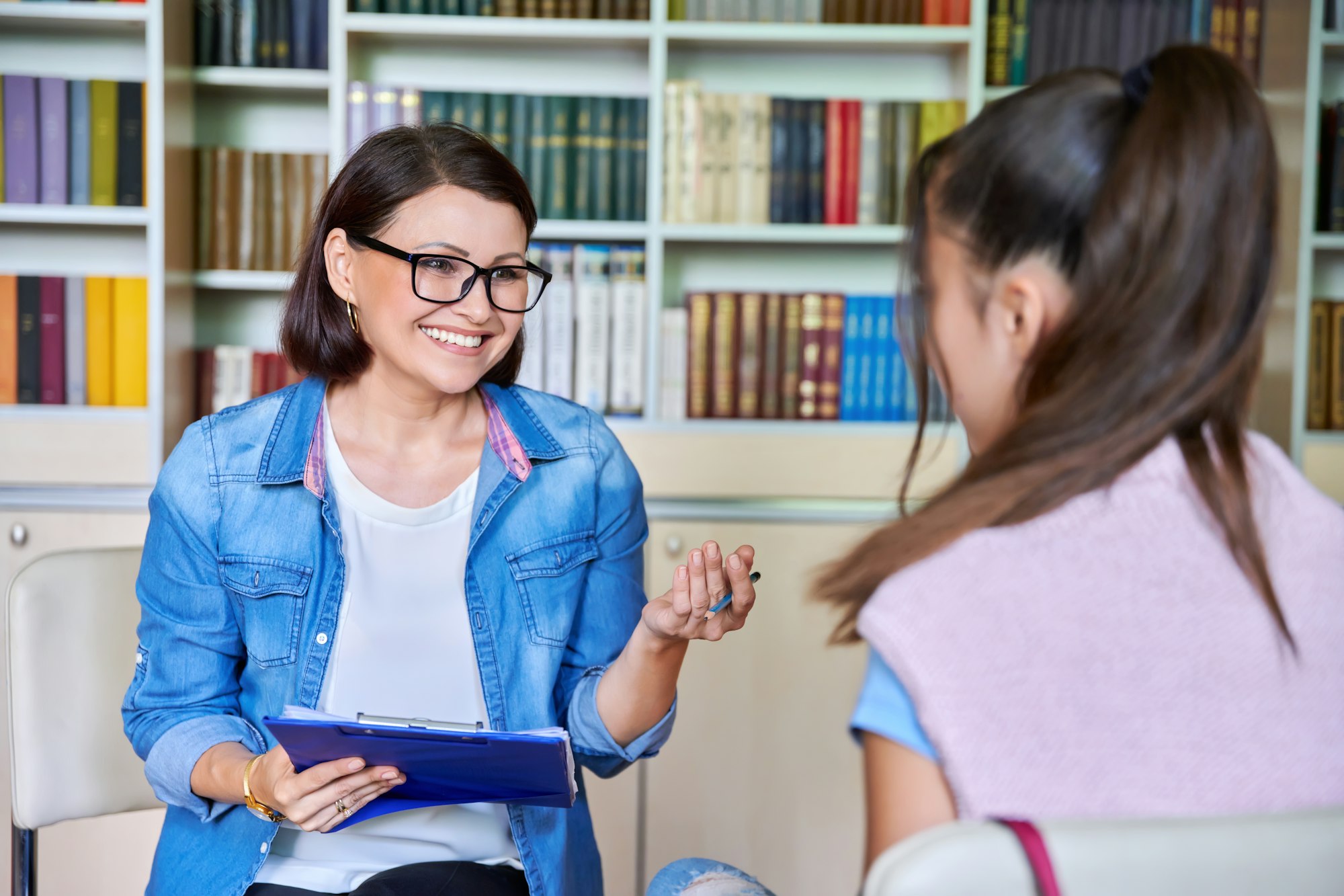 Woman school psychologist, teacher, social worker, mentor working with teenage girl